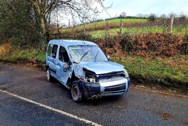 Firefighters deal with car on its side blocking the road