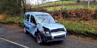 Firefighters deal with car on its side blocking the road
