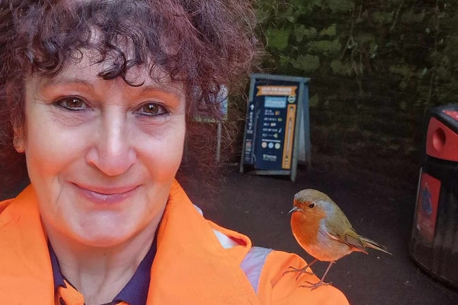 Dawn Kiff, 58 with a robin. Release date  March 19 2024. See SWNS story SWLNrobin. A woman who began feeding robins while on her coffee breaks says they now land on her head, sing to her  and even know her routine. Dawn Kiff, 58, began working as a cleansing operative in Shaldon, Devon, nine months ago, spending a lot of time in and around the heavily forested Smugglers Tunnel as a result. But over the past month, she has become a familiar face in the village  after befriending a family of friendly robins during her coffee breaks. I first noticed them back in October when the leaves were coming down and I had to clean around the tunnel, said Dawn. 