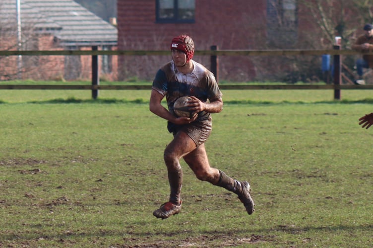 Teignmouth player of the match Alex Ford breaking out of defence