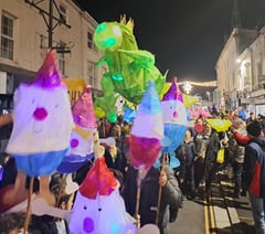 Children proudly carry Christmas lanterns in town parade 
