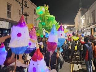 Children proudly carry Christmas lanterns in town parade 