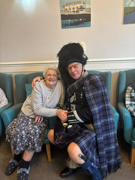 Mrs McKelvie with the bagpiper at Doneraile Care Home, Teignmouth