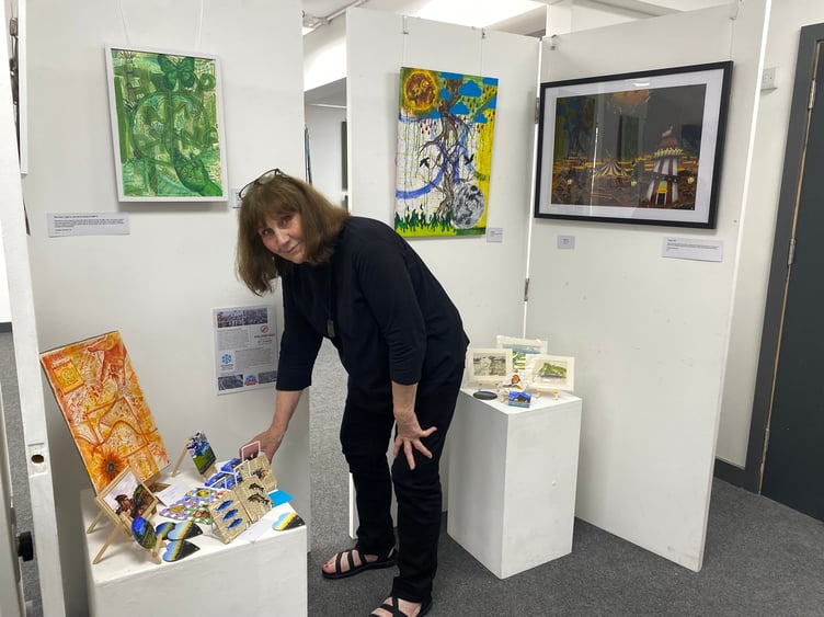Liz Lockyear, chair of trustees, with some of the under-19s art exhibits at TAAG